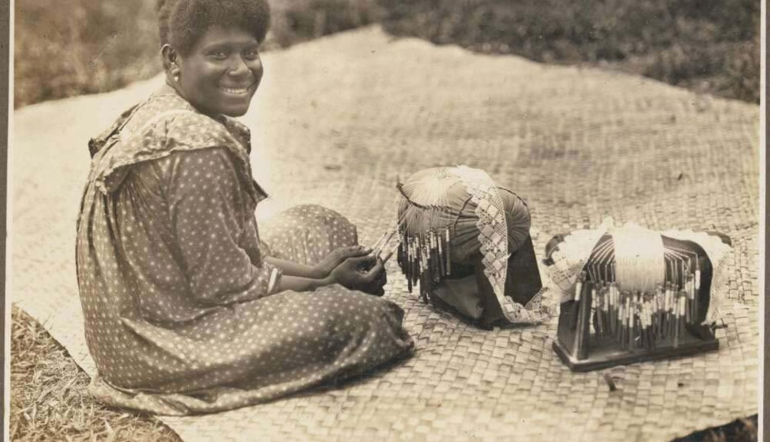 photo of a woman sitting on a mat looking over her right shoulder at the camera