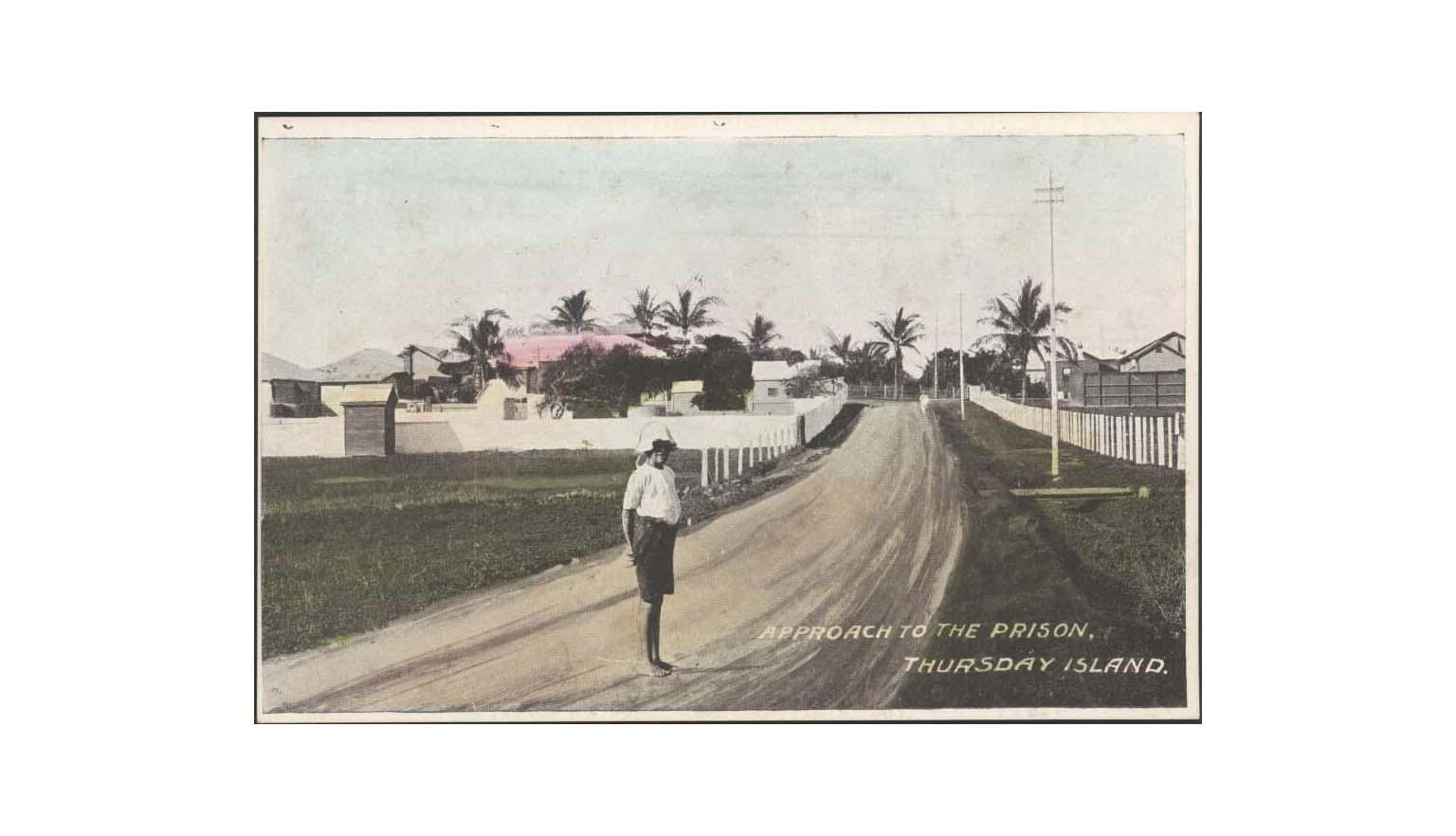 photo of a person standing on a dirt road. words written on the photo say 'Approach to the prison. Thursday Island.'