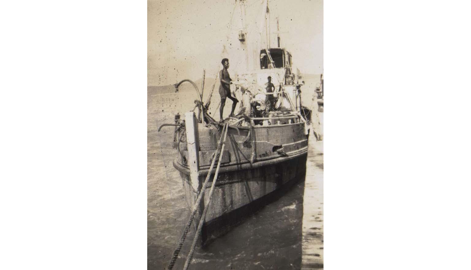 sepia photo of two men standing on the deck of a boat