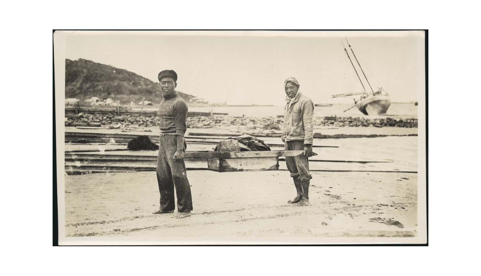 postcard depicting two pearl shellers carrying oysters between them