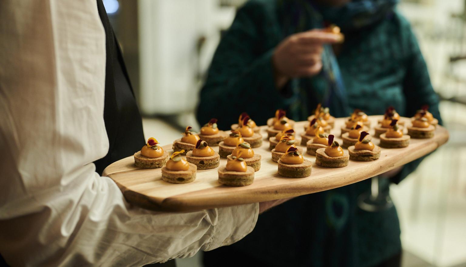 Event catering with a wooden tray of bite size treats
