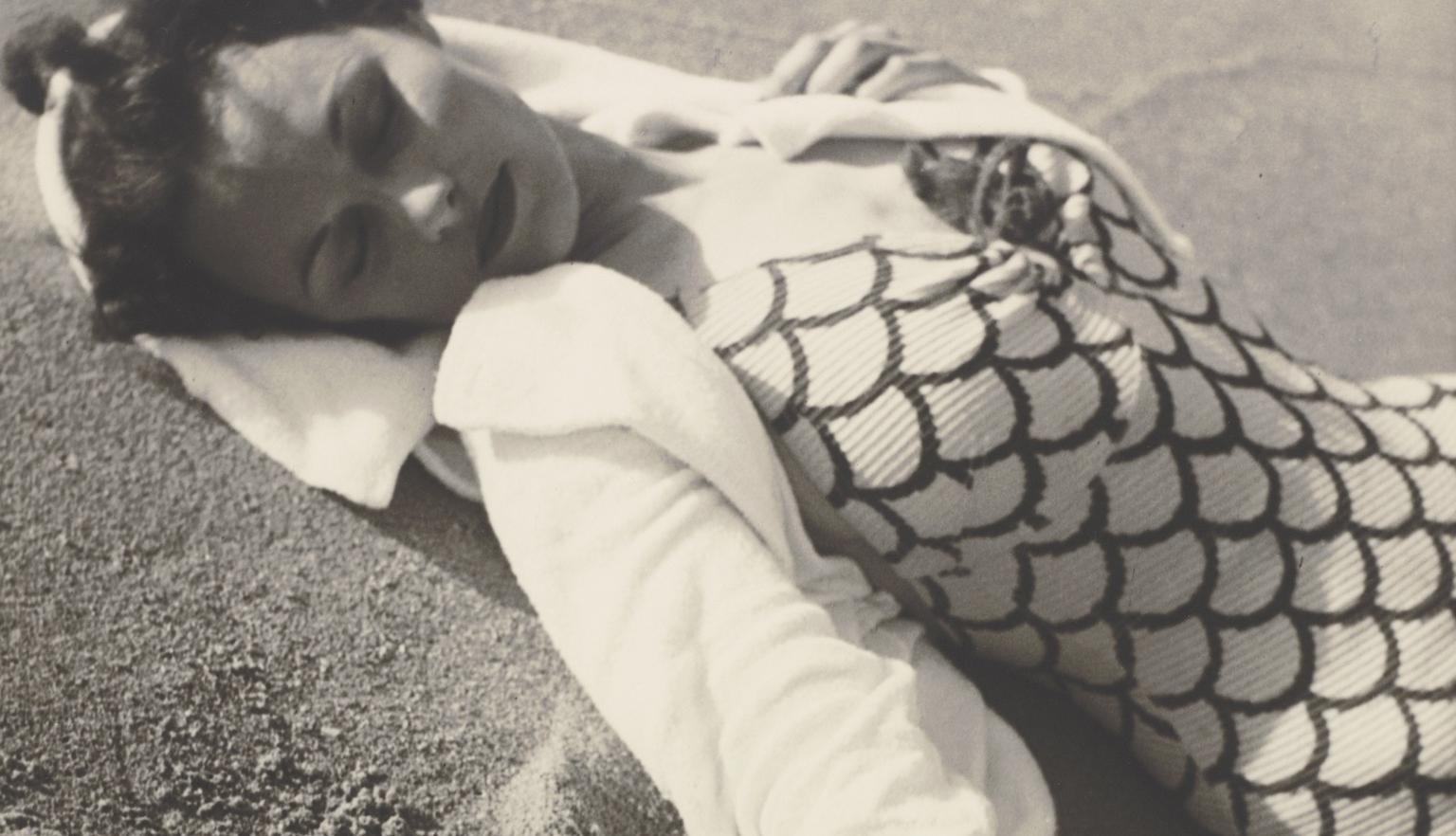 Woman lying on the beach with her eyes closed wearing beachwear fashion