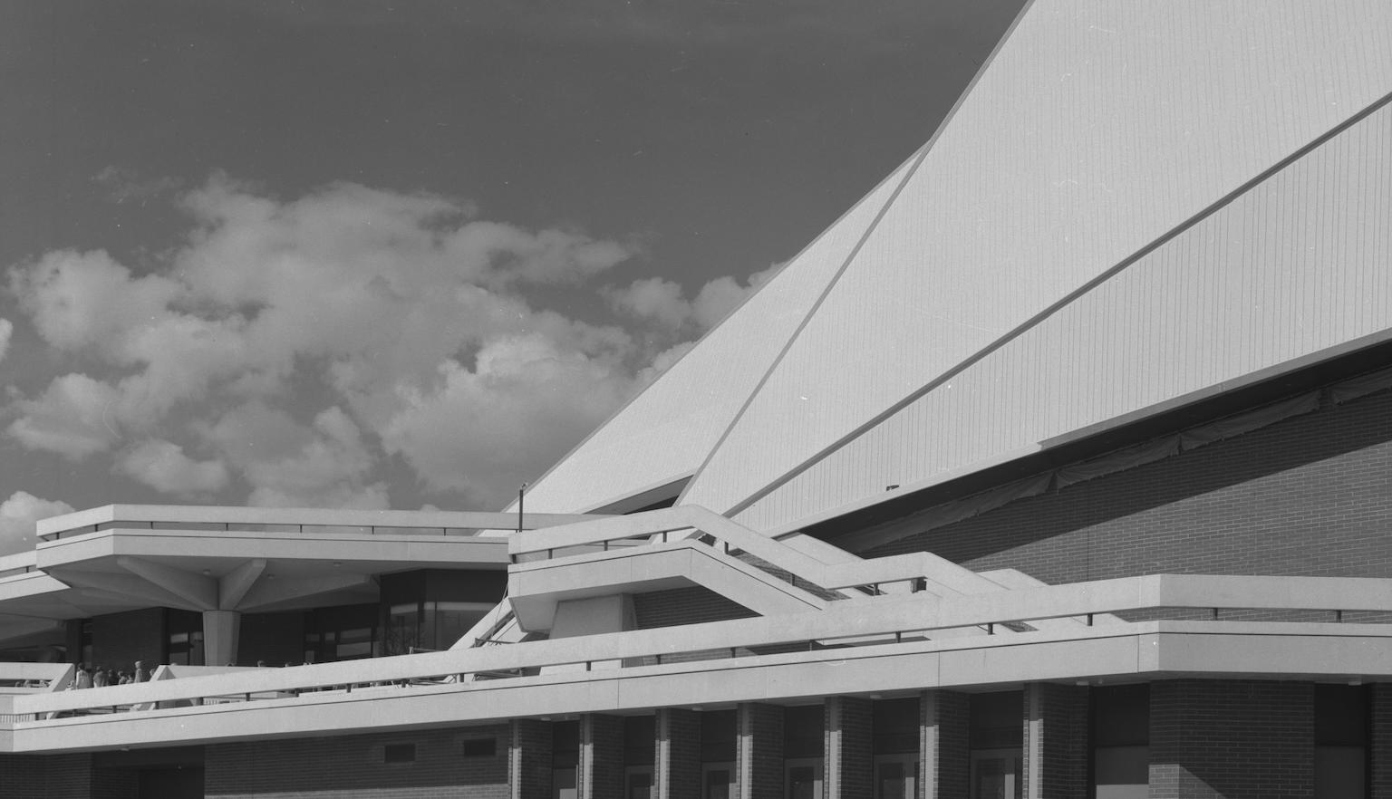 Black and white photo of a building with serval sharp angular lines and outdoor balconies.