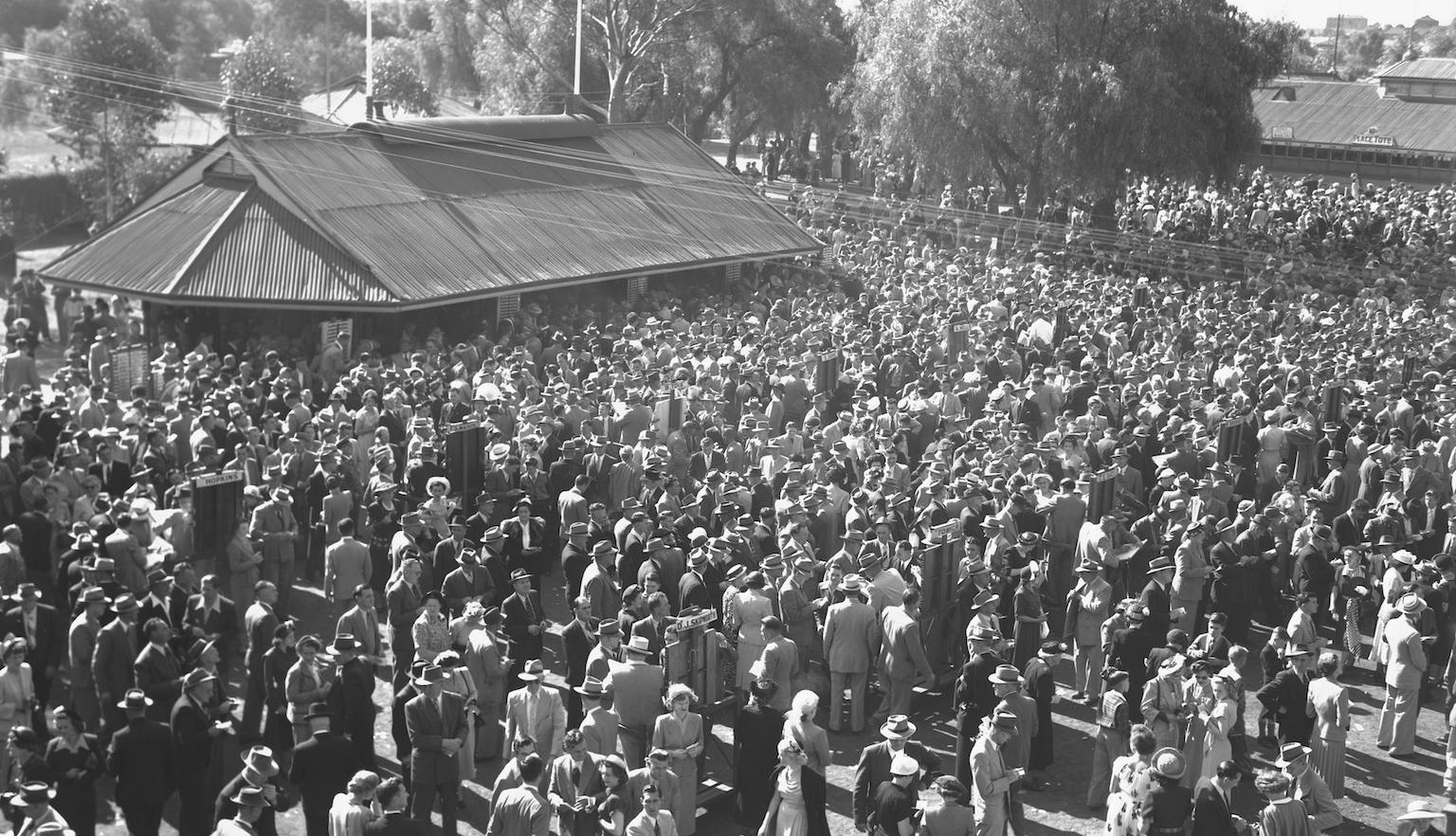 A large crowd of formally dressed people gathered for the races at Kalgoorlie. 