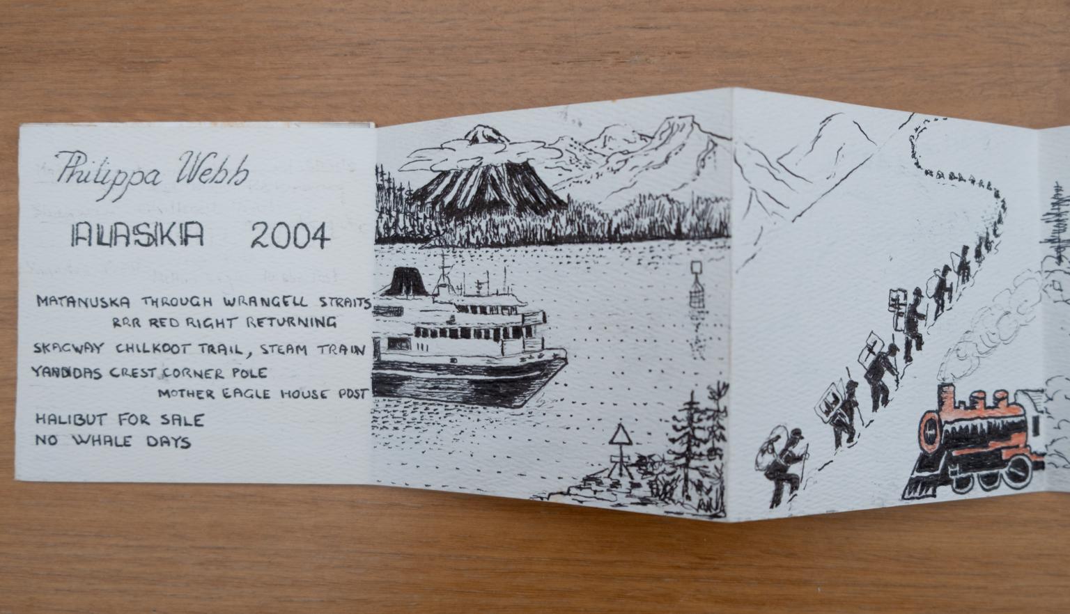 Fold-out travel diary open to four pages with black and white illustrations of a boat approaching the Alaskan shore and a long line of people walking up a mountain near a train