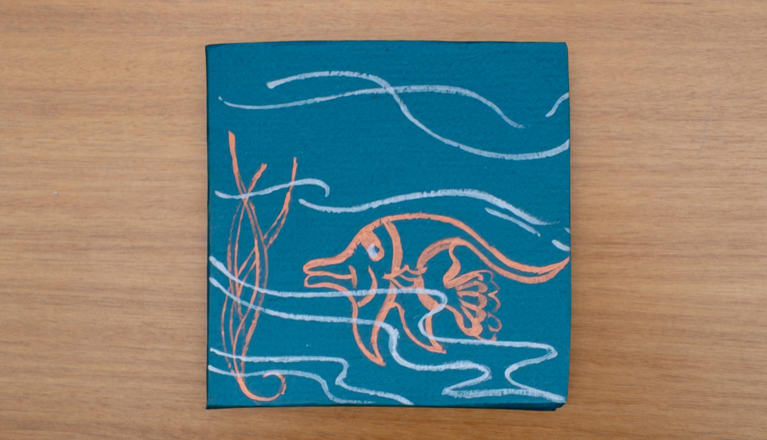 Blue slipcase with simple illustrations of waves and an orange fish