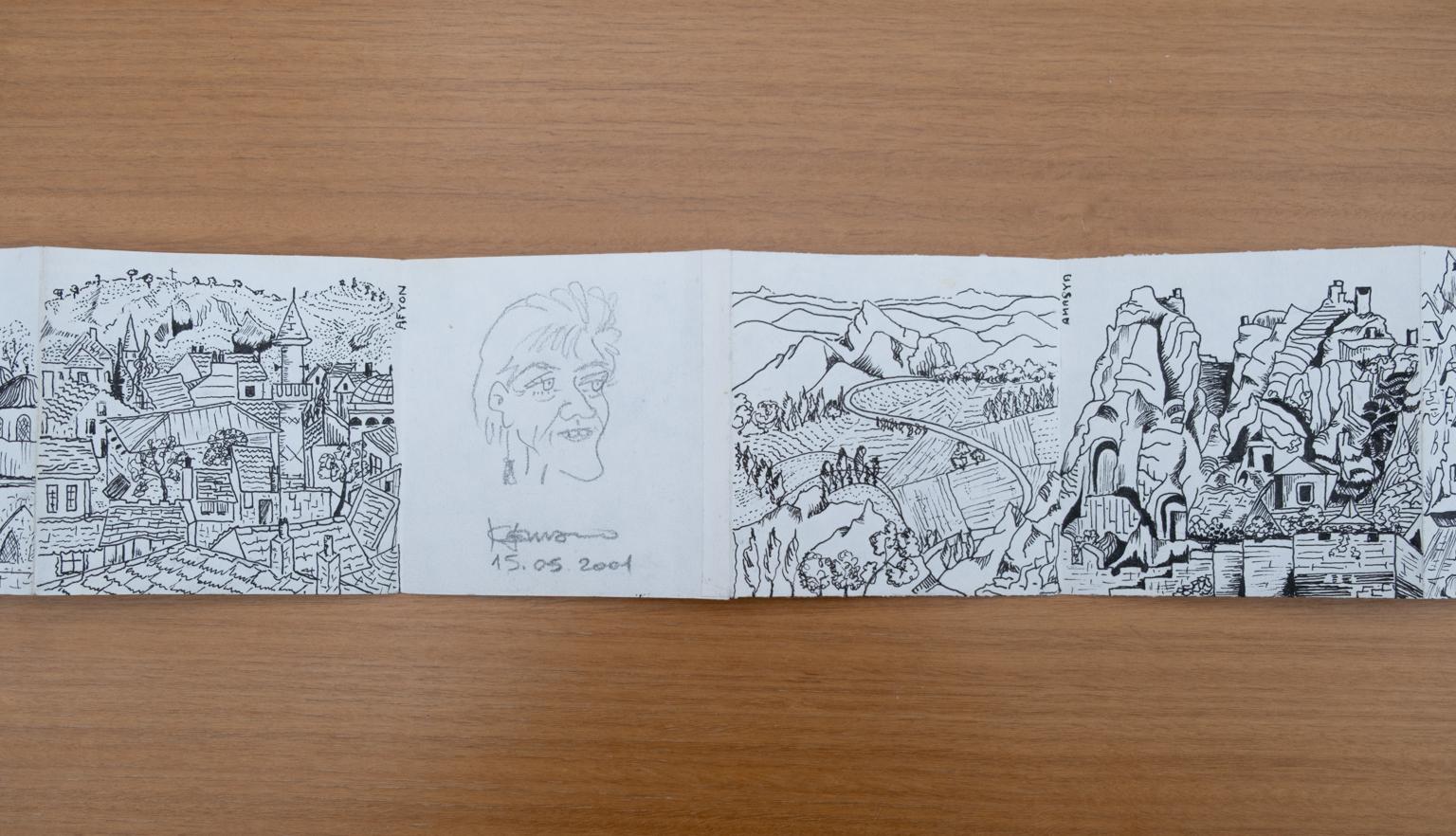 Fold-out travel diary open to four pages with black and white illustrations of people, landscapes and buildings in Turkey