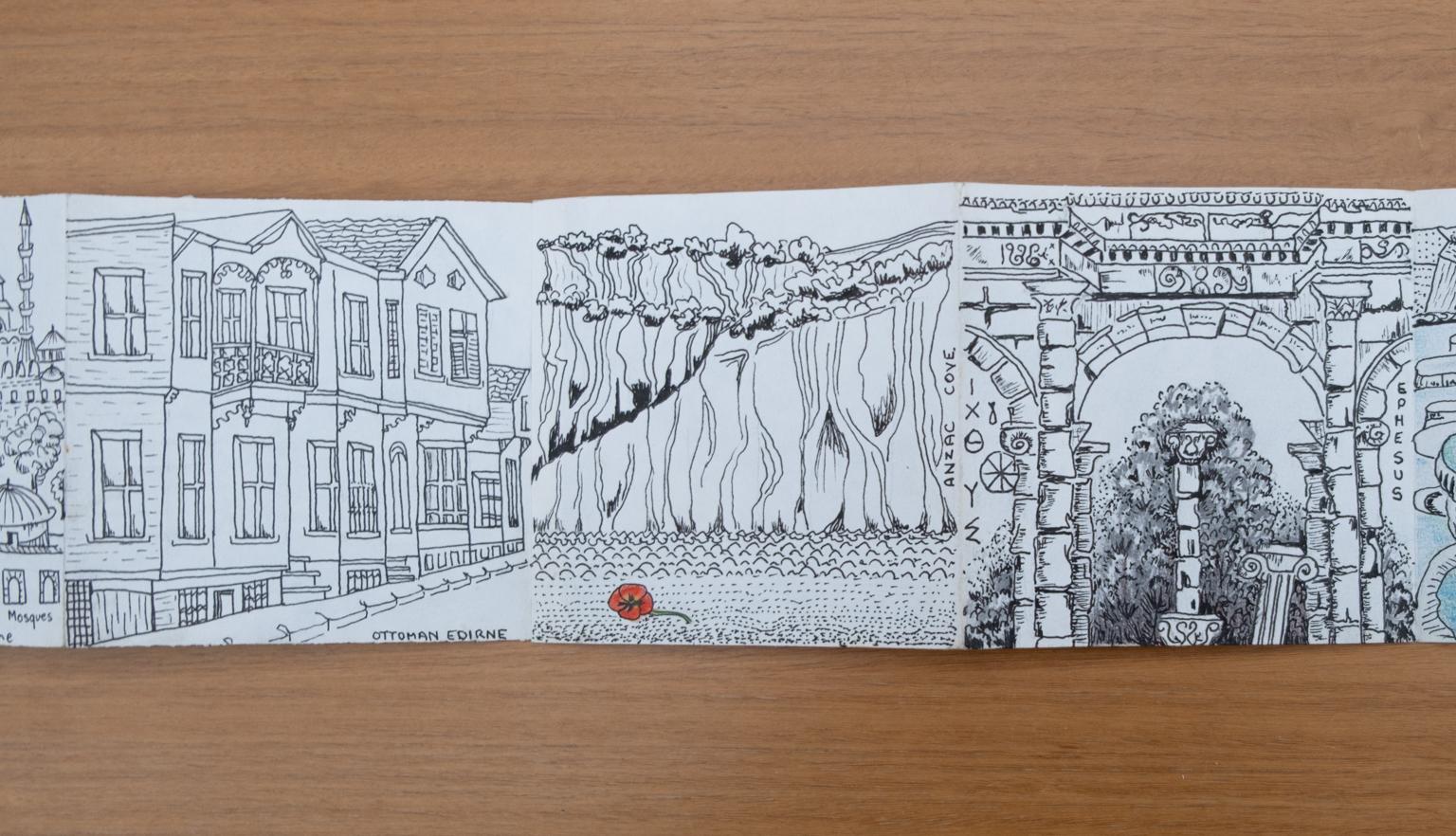 Fold-out travel diary open to three pages with black and white illustrations of architecture and a cliffside in Turkey