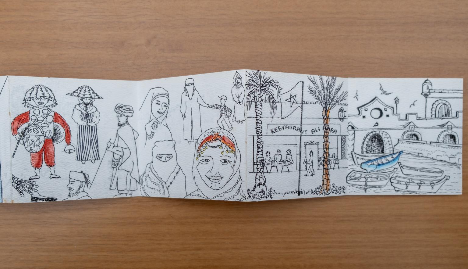 Fold-out travel diary open to three pages with black and white illustrations of Moroccan people and streets