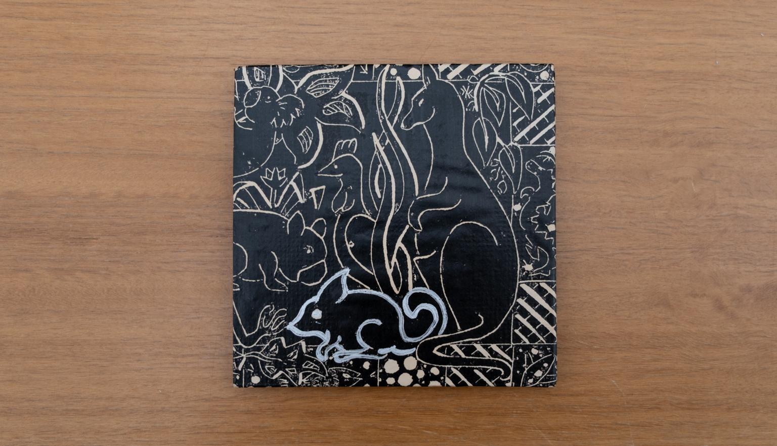 Travel diary cover with a black background and brown and white illustrations of Australian plants and animals , including a kangaroo and a bilby