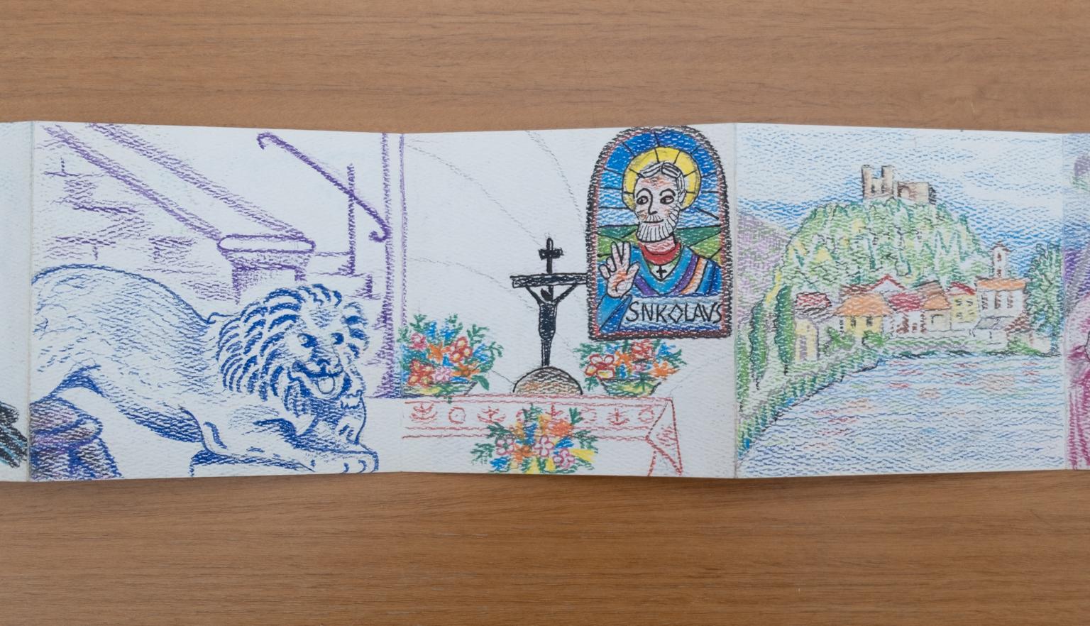 Fold-out travel diary open to three pages with colourful illustrations of a lion sculpture, inside a church and a town on the shore
