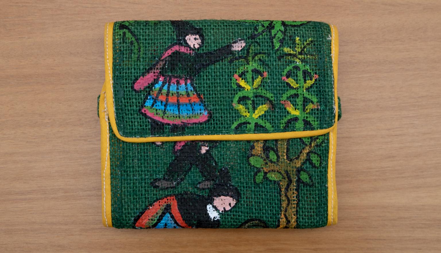 Green fabric pouch with people tending to trees painted on it