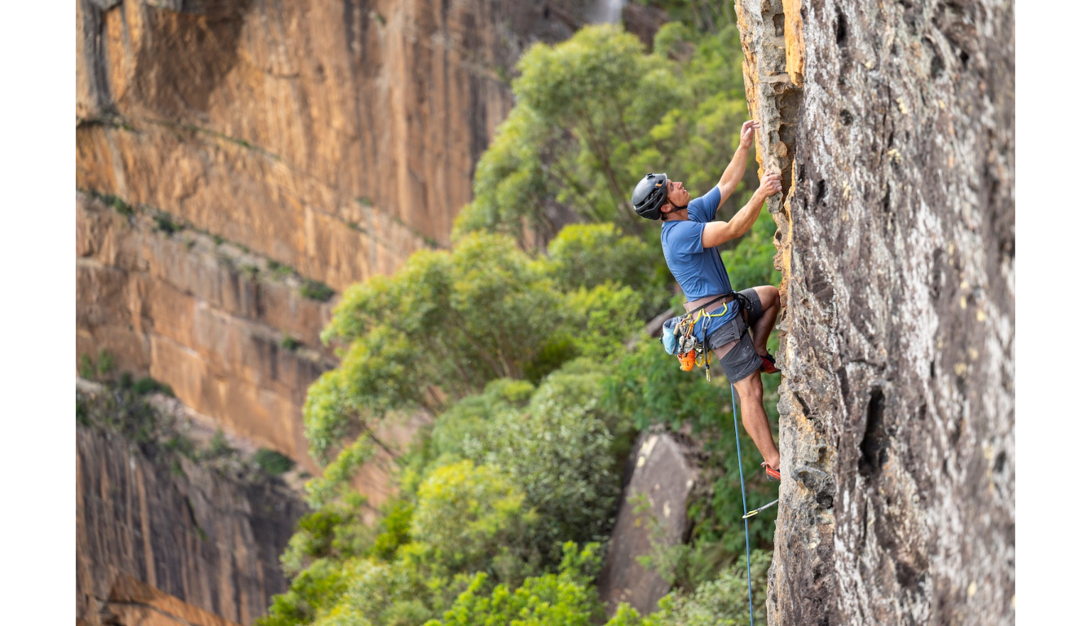 Male mountain climber on a steep rocky cliff face