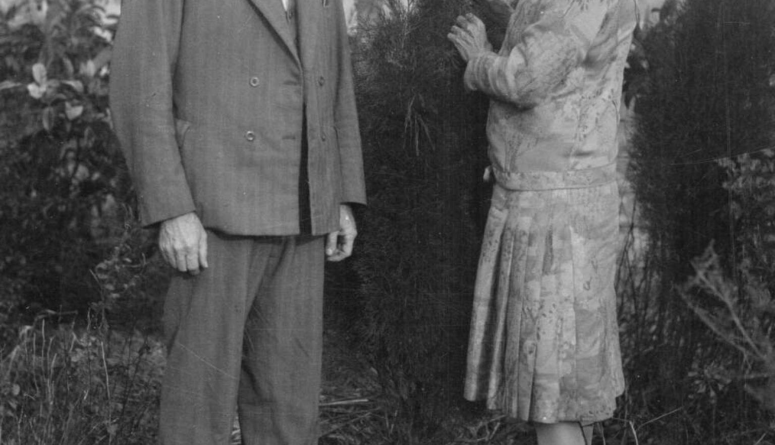 A black and white portrait of Walter Burley Griffin and Marion Mahony Griffin standing in a garden