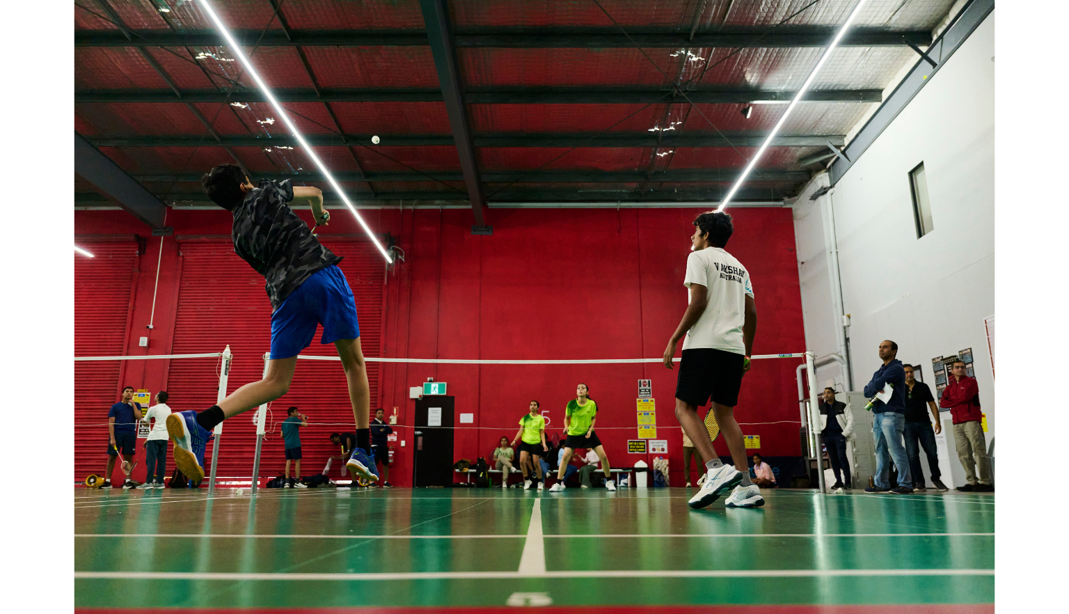 Man mid-jump during a game of badminton