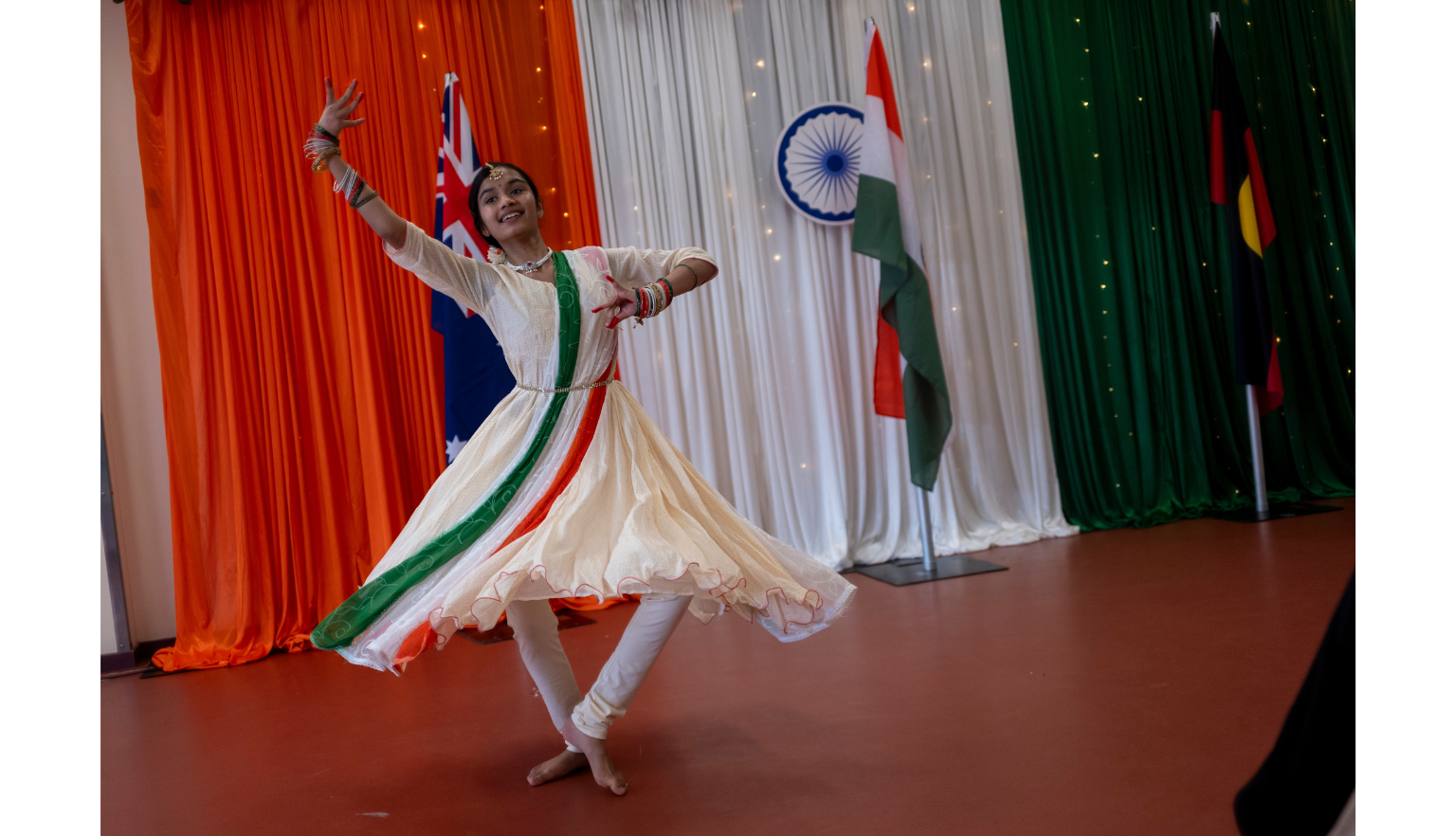 Young woman in a dress with stripes the colours of the Indian flag dancing