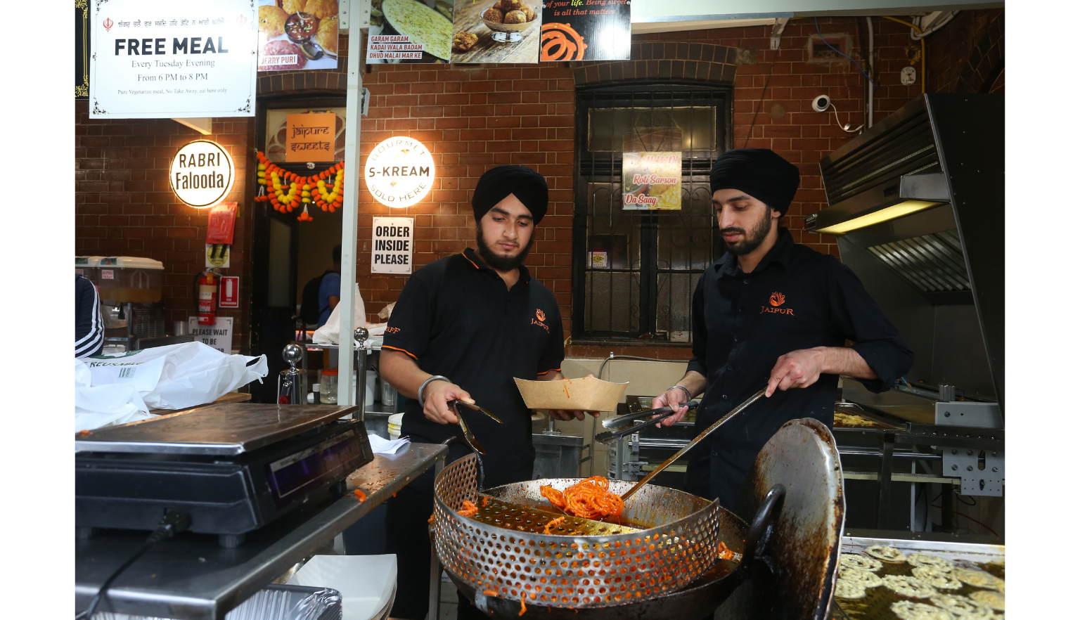 Two men making traditional Indian sweets at a restaurant