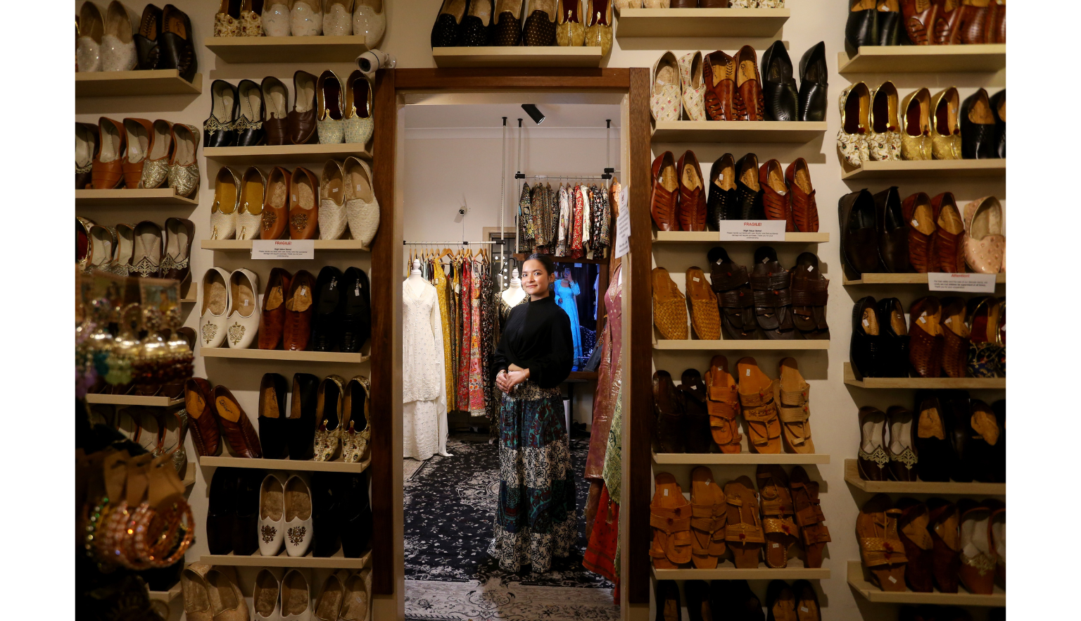 Woman standing near floor-to-ceiling shelves of shoes