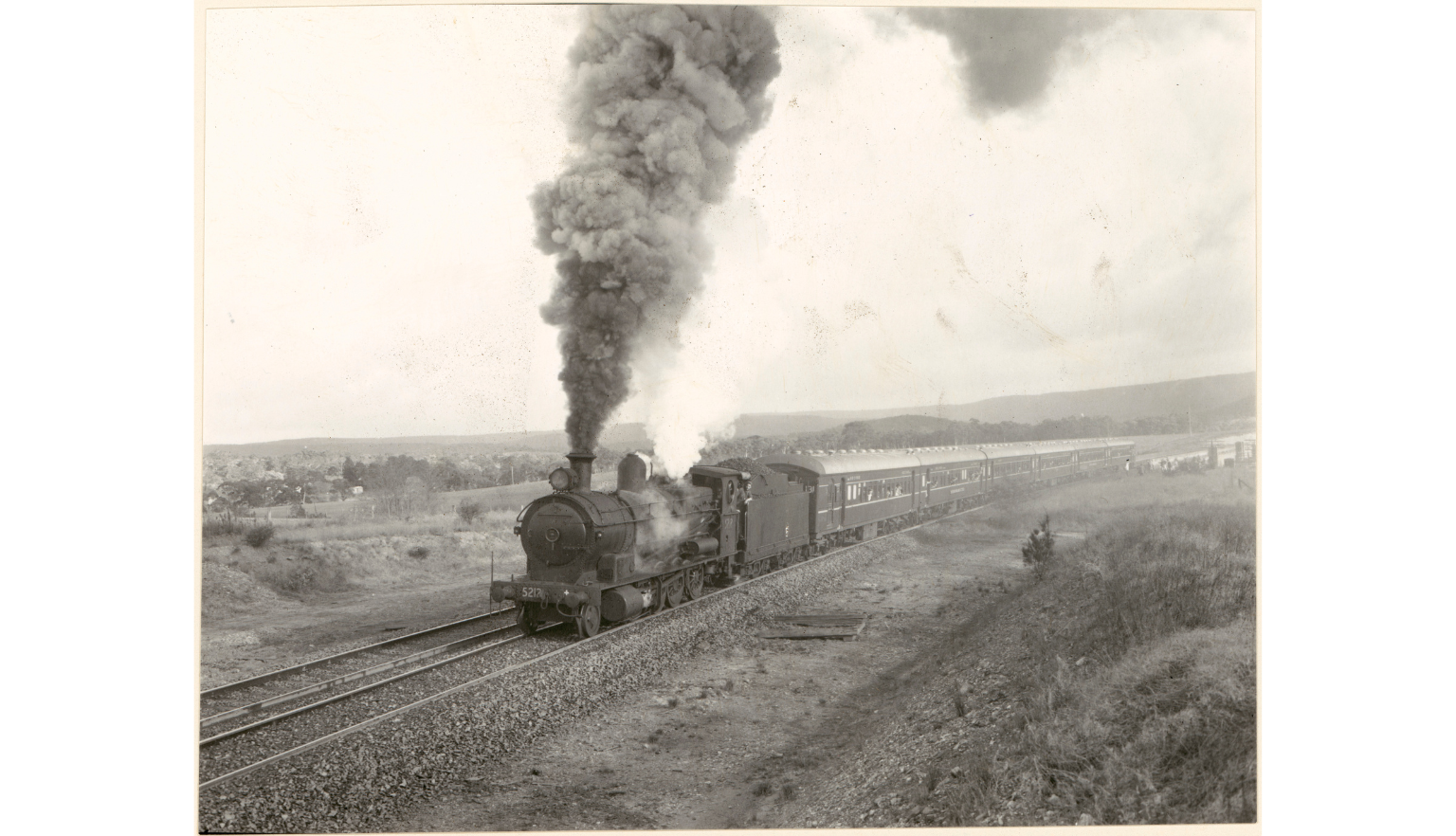 A black and white photograph showing a steam train on a track