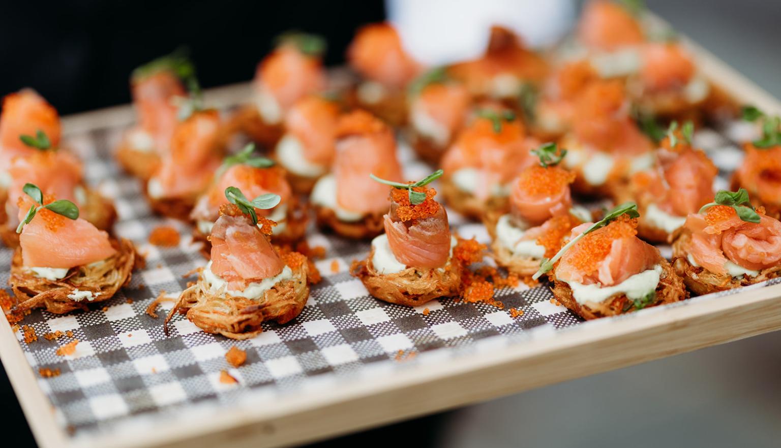 Small appetisers with smoked salmon on a tray