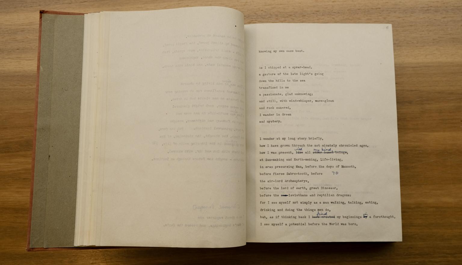 Book open to a make with type-written words of a poem with handwritten annotations and minor edits