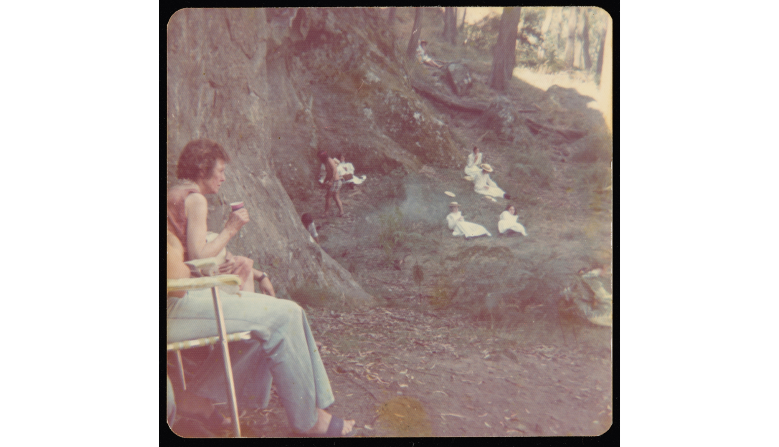 A woman almost out of frame on the left of this image watches actors on set