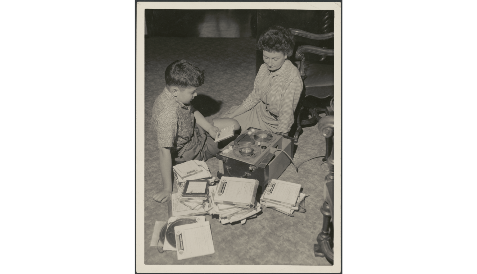 Black and white picture of Hazel de Berg sitting on the floor with her son