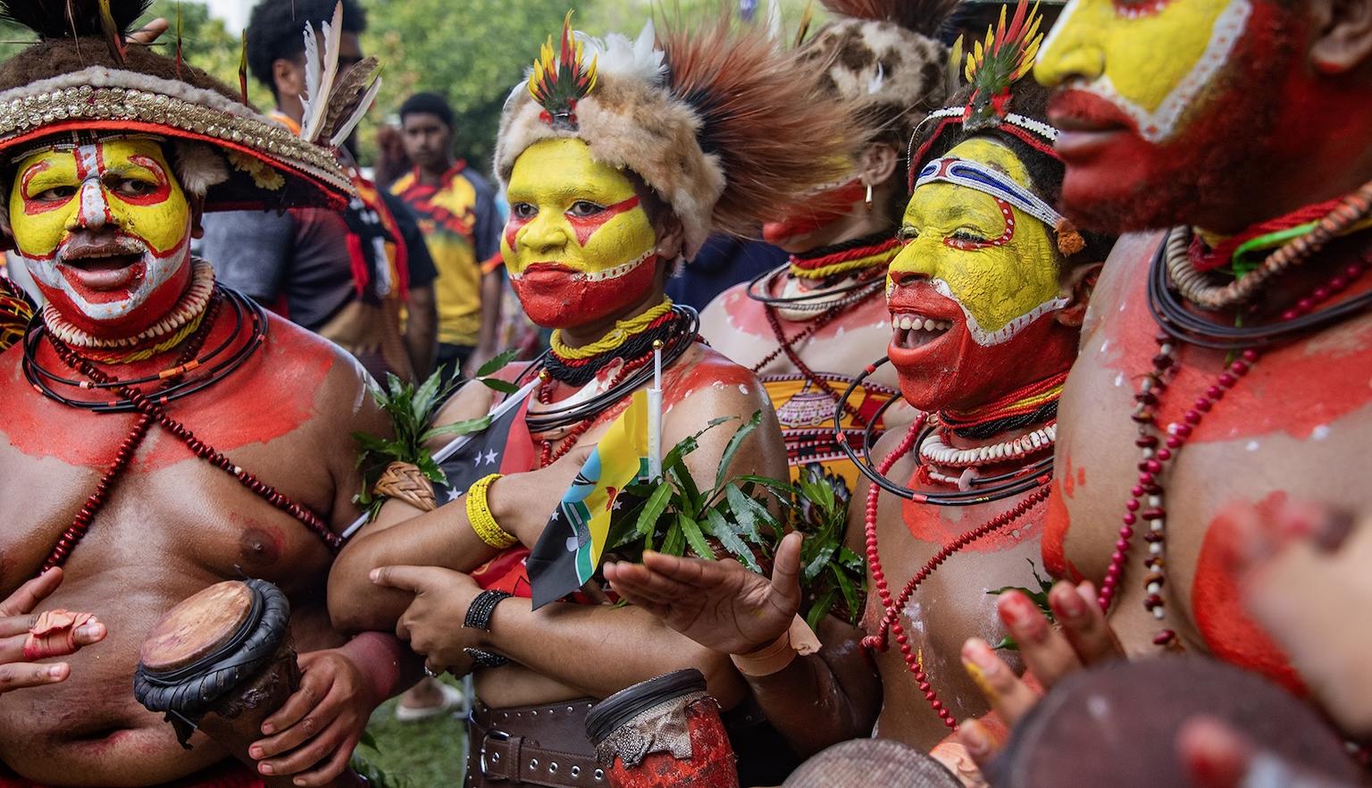 Men and women of a Papua New Guinea dance group with painted faces and colourful outfits