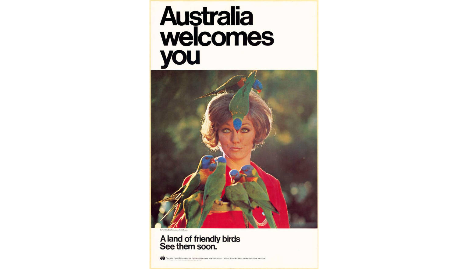 A vintage Australian tourism poster featuring a woman in a red top with colorful rainbow lorikeets perched on her head and shoulders. The text reads 'Australia welcomes you' and 'A land of friendly birds. See them soon.'