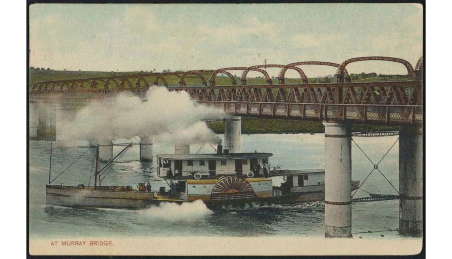 Paddle steamer passing beneath a large iron bridge, with steam billowing across the river.