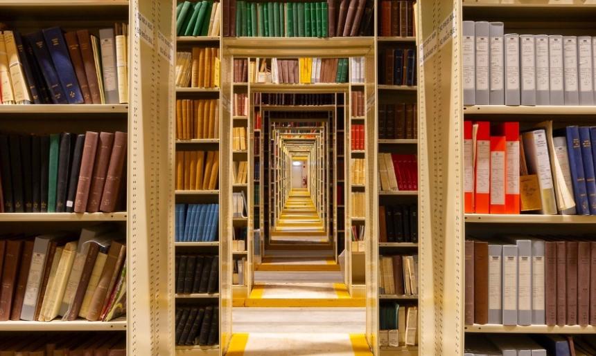 Rows of shelves filled with colourful books and doorways lined down the middle