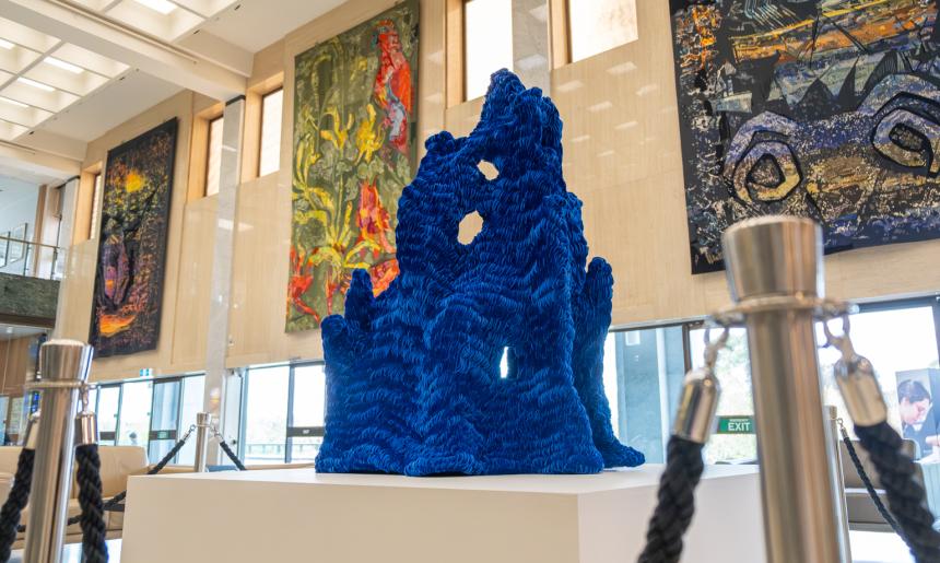 Blue velvet structural artwork on a white pedestal in the Library foyer