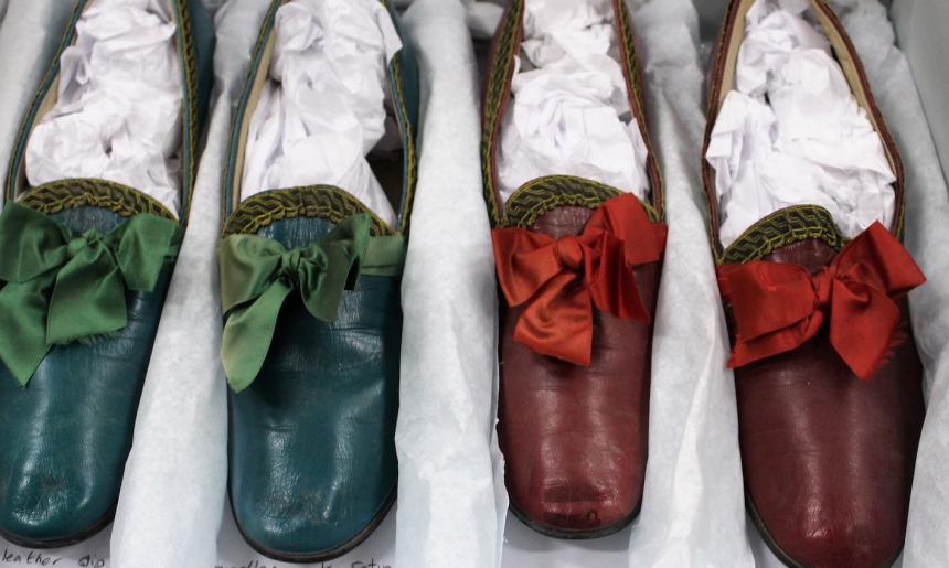Two pairs of slippers, one green and one red, made from leather with silk bows