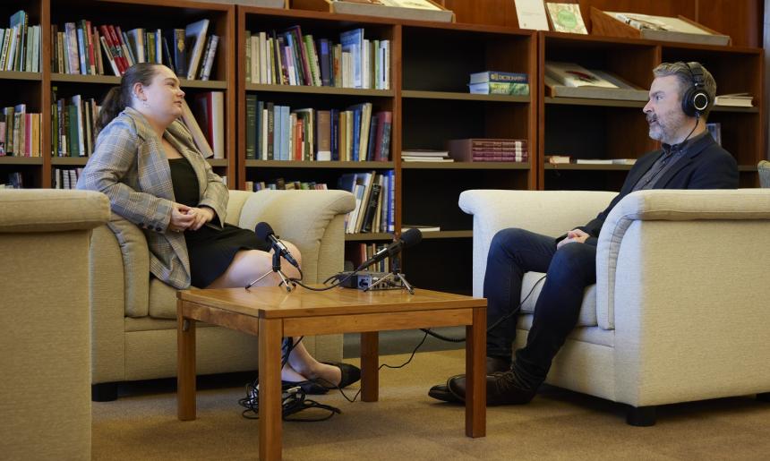 A man and woman sitting on couches recording an oral history interview