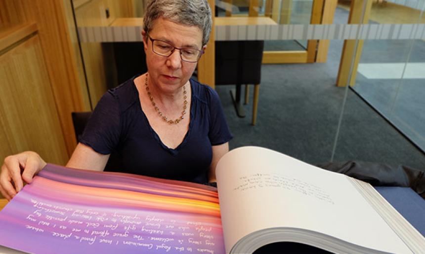 Director-General of the National Library of Australia, Marie-Louise Ayres reading the book 'Message to Australia'