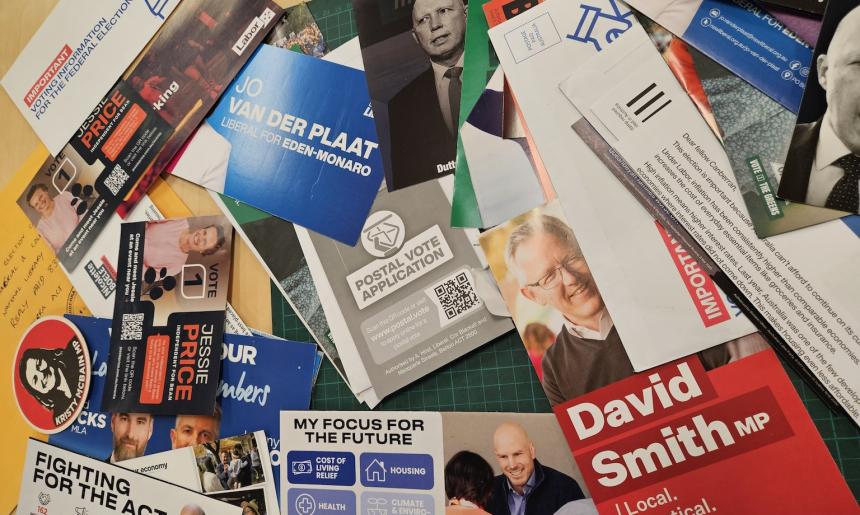 A variety of recently donated 2025 election campaign material laid out on a table. 