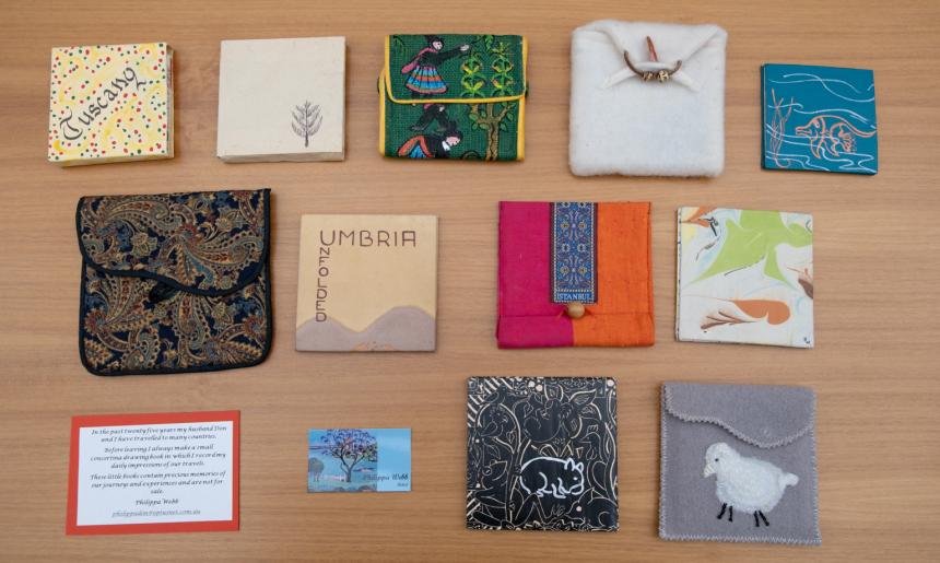 Small handmade diaries of various sizes and designs, some in fabric cases