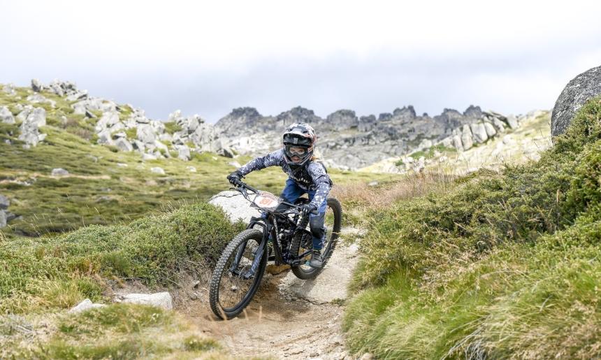 Mountain biker in full gear riding a rocky, dirt path