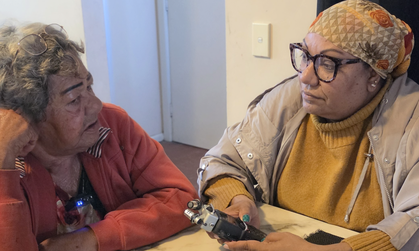 Two First Nations women sitting at a table conducting an oral history interview.