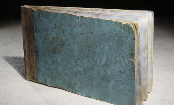 A photo of a tattered old blue book.