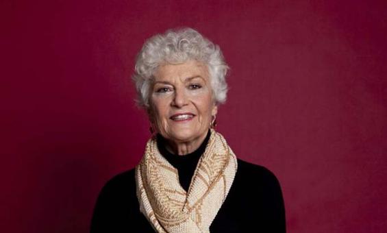 photo of a woman standing against a purple background