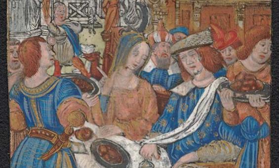 A colourful image of a feast. Men and women are dressed in colourful clothes. There is a table with a white tablecloth. There is a plate of food on the table.