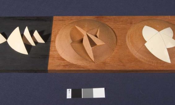 A stylised, abstract architects model of the Sydney Opera House. The model shows a hemisphere with triangular segments removed, another hemisphere shows the segments replaced to create a smooth surface.