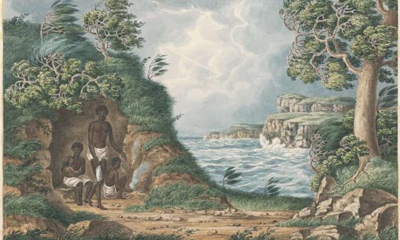 Family of aboriginal people sitting by a bay surrounded by trees.