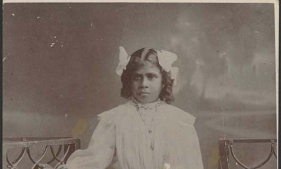 Black and white photo of an Aboriginal girl dressed in white clothing