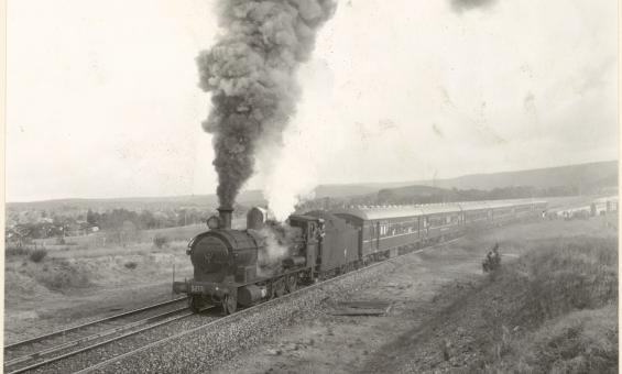 A black and white photograph showing a steam train on a track