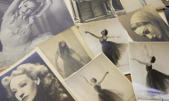 Photographs spread on a table, of a woman throughout her career in ballet, including photos of her dancing and portraits