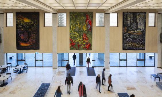 Three colourful tapestries hanging above the main entrance doors