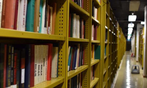 Metal shelves full of bound volumes in many different colours