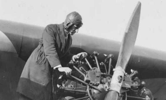 Charles Kingsford Smith examining the propeller of a plane
